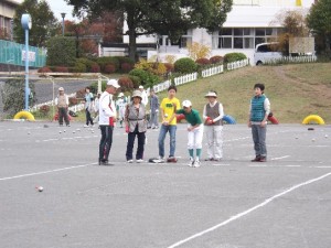 〔目印の赤い球をめがけ、できるだけその近くで止まるように、各チームがそれぞれ鉄球を放る〕